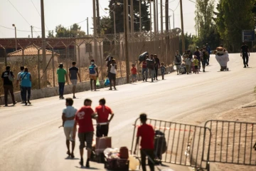 Des migrants entrent le 16 septembre dans un nouveau camp aménagé sur l'île grecque de Lesbos après l'incendie du camp de Moria 