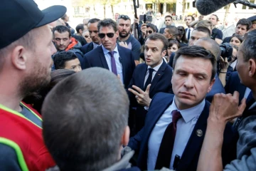 Emmanuel Macron (C) discute avec des manifestants opposés à ses réformes à Saint-Dié-des-Vosges, le 18 avril 2018