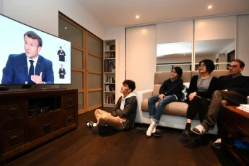 Famille française devant l'interview télévisée du président Emmanuel Macron, annonçant l'imposition de couvre-feux nocturnes, à Fouesnant (ouest), le 14 octobre 2020