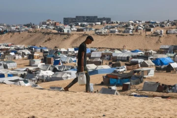 Un Palestinien transporte de l'eau dans un camp de déplacés à Rafah, dans le sud de la bande de Gaza, le 4 avril 2024