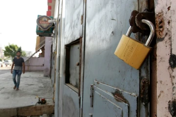 Un Irakien passe devant la porte fermée d'un magasin vendant de l'alcool à Bagdad le 23 octobre 2016 