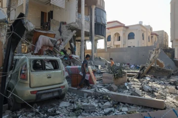 Les Palestiniens inspectent les dégâts causés par un bombardement d'une maison dans le camp de réfugiés de Nousseirat, dans le centre de la bande de Gaza, le 14 août 2024