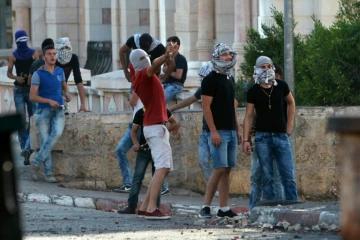 Des Palestiniens lancent des pierres sur les forces israéliennes de sécurité le 15 octobre 2015 à Bethlehem