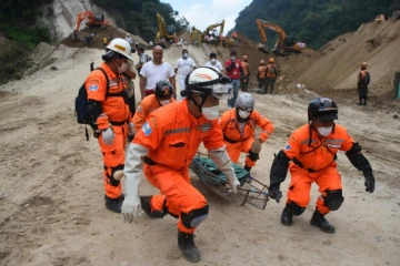 Des équipes de secours transportent le corps d'une victime après un glissement de terrain  à Santa Catarina Pinula, le 6 octobre 2015 au Guatemala