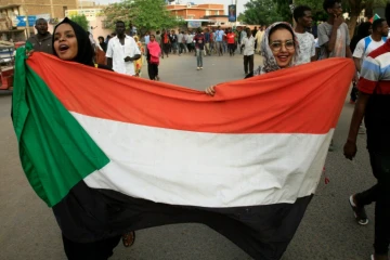 Des femmes soudanaises manifestent contre le Conseil militaire de transistion brandissant le drapeau national le 30 juin 2019 dans le centre de Khartoum