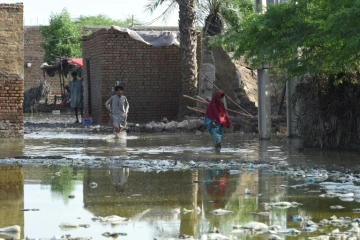 Des habitants dans une zone inondée près de Sukkur, dans la province du Sind, au Pakistan