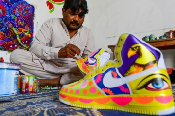 L&rsquo;artiste Haider Ali peint une paire de baskets dans son studio de Karachi, le 28 février 2022
