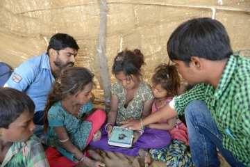 Anand Solanki (D) fait découvrir internet à des enfants du désert du Gujarat, en Inde, le 7 avril 2017