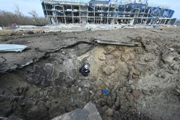 Le cratère laissé par une frappe de missiles russes devant un centre commercial détruit à Kharkiv, est de l'Ukraine, le 6 avril 2024
