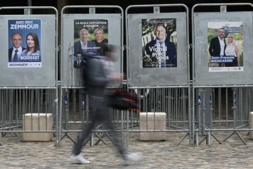 Passant marchant devant des affiches électorales à Montpellier, le 8 juin 2022