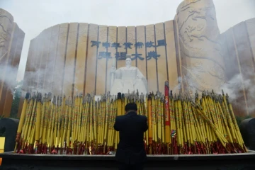 Un homme salue la statue de l'Empereur jaune le 9 avril 2016 lors d'une cérémonie à Xinzheng, en Chine