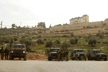 Des soldats israéliens contrôlent l'accès à au village de Karma près de Hébron après une attaque au couteau dans une colonie, le 18 janvier 2016 en Cisjordanie