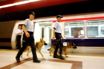 Deux policiers turques marchent avec leurs chiens dans le métro d'Istanbul, le 11 juillet 2005 