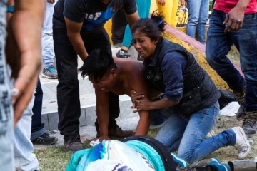 Les proches d'une victime de l'explosion de feux d'artifice, près de son corps le 20 décembre 2016 à Mexico