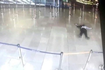 Photo prise sur un écran de télévision le 18 mars 2017 montrant un homme gisant sur le sol à l'aéroport d'Orly après avoir pris une arme à un militaire