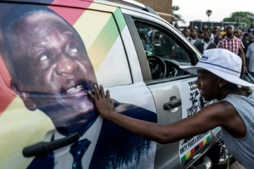 Une supportrice d'Emmerson Mnangagwa touche son image  peinte sur un véhicule, le 22 novembre 2017 à Harare