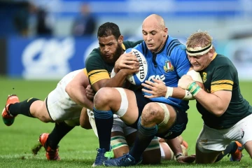 L'Italien Sergio Parisse (c) est plaqué par les Sud-Africains Rudy Paige (g) et Adriaan Strauss (d) en test-match, le 19 novembre 2016 à Florence 