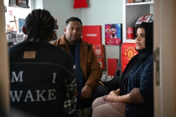 Uzma Naveed, coordinatrice, et Jeffrey Andrews, travailleur social, parlent à "John" dans un bureau de Centre d'action chrétien pour les réfugiés à Hong Kong