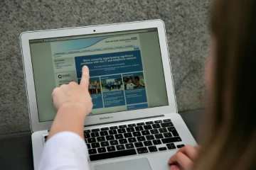Une femme montre le site Web du NHS (East and North Hertfordshire), informant les utilisateurs d'un problème dans son réseau, à Londres le 12 mai 2017