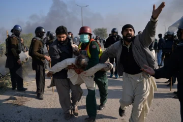 Des manifestants islamistes pakistanais évacuent l'un des leurs blessé lors d'affrontements avec la police samedi 25 novembre 2017 à Islamabad