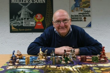 Tom Werneck, collectionneur de 79 ans, pose derrière un jeu de plateau aux archives Bayerisches Spielearchiv des jeux de société, à Munich, dans le sud de l'Allemagne, le 12 décembre 2018 