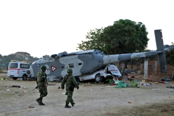 Des soldats de l'armée mexicaine marchent devant l'hélicoptère militaire et la camionnette à Santiago Jamiltepec, État d'Oaxaca, au Mexique, le 17 février 2018