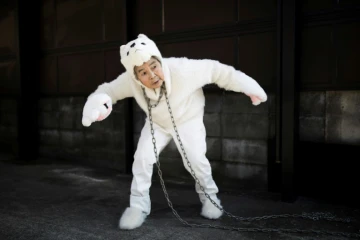 La Japonaise Kimiko Nishimoto vêtue d'un costume de chien pose pour un selfie devant sa maison, le 16 janvier 2018 à Kumamoto