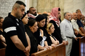 Des personnes assistent à une messe célébrée pour les victimes d'un incendie dans une salle de mariage, le 28 septembre 2023 dans une église de Qaraqosh, en Irak