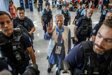 Le prix Nobel de la Paix Muhammad Yunus est escorté par la police française avant son départ pour le Bangladesh, le 7 août 2024 à l'aéroport de Paris-CDG.