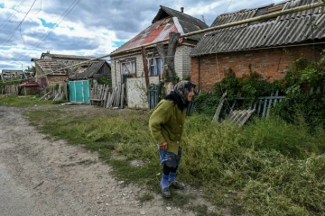 Une habitante passe devant des maisons endommagées de la localité de Siversk, dans la région de Donetsk, prise entre les tirs des forces ukrainiennes et russes, le 7 septembre 2022