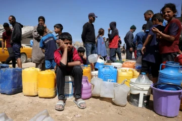 Des Palestiniens attendent de pouvoir obtenir de l’eau dans un camp de personnes déplacées à Gaza-Ville, le 20 mai 2025, sur fond de guerre entre Israël et le mouvement palestinien Hamas