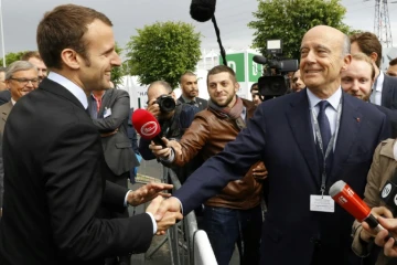 Le Président Emmanuel Macron, alors ministre de l'Économie, serre la main du maire de Bordeaux, Alain Juppé, à Villepinte, près de Paris, le 16 juin 2016