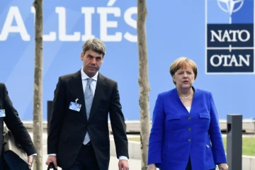 La chancelière allemande Angela Merkel arrive au siège de l'Otan à Bruxelles avec un collaborateur, le 11 juillet 2018. 