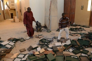 Des habitants de Tombouctou recueillent des documents anciens brûlés par les islamistes au Centre de documentation et de recherche Ahmed Baba, le 29 janvier 2013 au Mali