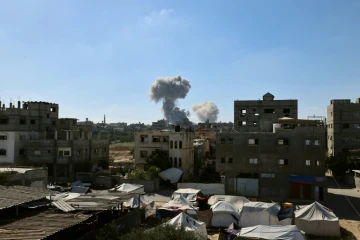 De la fumée s'élève en arrière-plan lors d'une frappe israélienne dans le centre de la bande de Gaza, le 29 mai 2025