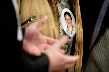 Un membre de la famille d'Anne Barbot porte le portrait de la victime en médaillon, le 14 janvier 2016 au palais de justice de Nantes
