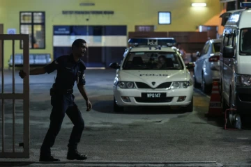 Un policier referme la barrière d'accès au bâtiment de médecine légale de l'hôpital de Kuala Lumpur où se trouve le corps de Kim Jong-Nam, demi-frère du leader nord-coréen Kim Jong-Un, le 27 février 2017 en Malaisie