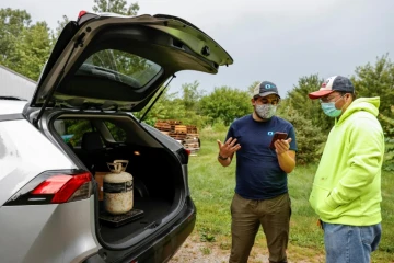 Chad Dorger (gauche), de l'entreprise Tradewater Refrigerant Solutions, achète une bonbonne de gaz nocif pour l'environnement à Rick Karas (droite), à Peotone dans l'Illinois le 11 août 2021