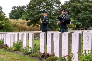 Un soldat canadien joue de la cornemuse pendant l'inhumation de quatre soldats canadiens tués pendant la Première Guerre Mondiale, à Loos-en-Gohelle, dans le nord de la France, le 23 août 2018