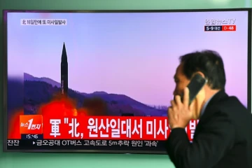 Un homme passe devant un écran de télévision montrant un tir de missile nord Coréen le 22 mars 2017 à Séoul