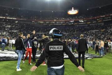 Des supporters lyonnais du Virage Sud envahissent la pelouse pour échapper à des jets de projectiles de supporters turcs, le 13 avril 2017 au Parc OL