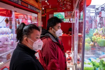 Des clients portent un masque de protection dans une boutique de Pékin, le 29 janvier 2020 en Chine
