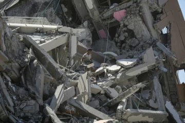 Un Palestinien tente de récupérer quelques affaires au milieu des décombres dans un secteur de Deir al Balah dont l'armée israélienne s'est retirée, le 29 août 2024
