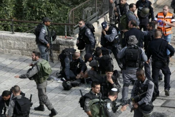 Un policier israélien agressé au couteau par un Palestinien reçoit les premiers soins entouré par ses collèges, le 10 octobre 2015 près de la Vieille ville de Jérusalem