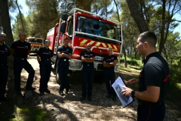 Des pompiers écoutent les instructions dans une forêt de Gardanne, le 25 juillet 2023 dans les Bouches-du-Rhône