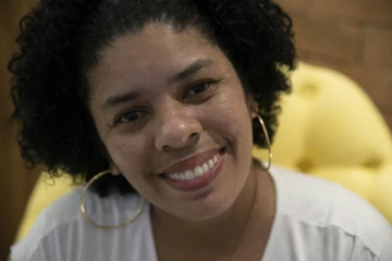 Ayant bénéficié de traitements de dentistes bénévoles pour récupérer une dentition détruite sous les coups de ses compagnons, Ana Claudia, 37 ans, sourit lors d'un entretien à l'AFP à Rio de Janeiro le 9 septembre 2019