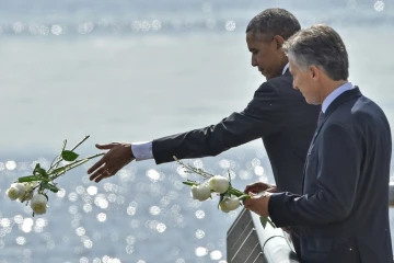 Les présidents américain Barack Obama et argentin  Mauricio Macri jettent des fleurs blanches dans River Plate en hommage aux victimes de la dictature le 24 mars 2016 à Buenos Aires 