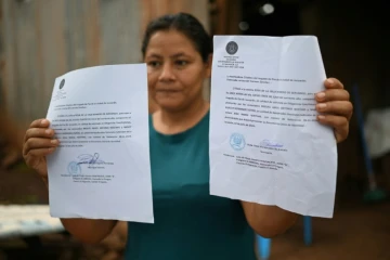 Rosa Romero montre deux assignations du tribunal de Jucuaran pour libérer la parcelle où elle vit sur la plage d'El Higueron, le 20 juillet 2024 au Salvador