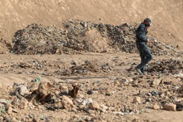 Un membre des forces de sécurité irakiennes au milieu d'une fosse découverte le 7 novembre 2016 à Mosssoul après la reprise de la ville au groupe EI