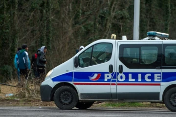 Des migrants et une voiture de police à Calais, le 3 mars 2017